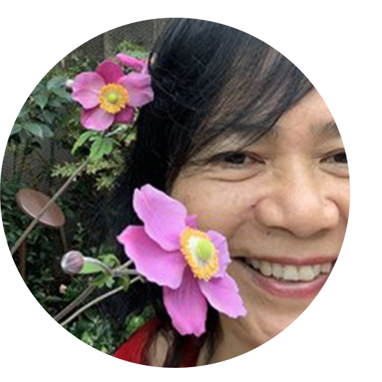 A woman wearing a sensor and holding her child in front of a fountain.