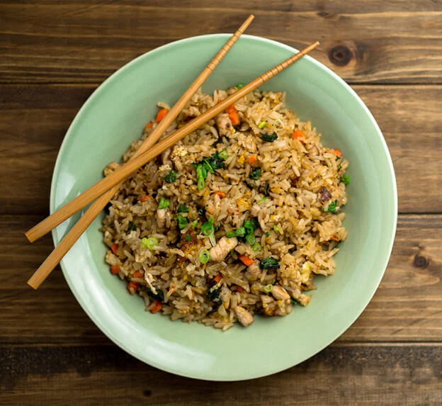 Arroz frito con verduras servido con palillos, versión ligera del plato tradicional