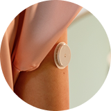 A close up image of a FreeStyle Libre sensor on the back of a person's arm.