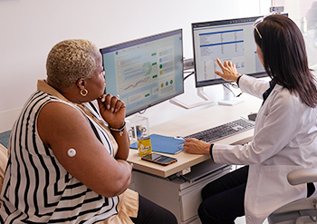 Médica analisando os relatórios de glicose de sua paciente em um consultório