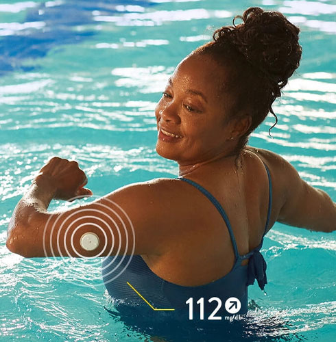 Mulher na piscina com o sensor FreeStyle Libre