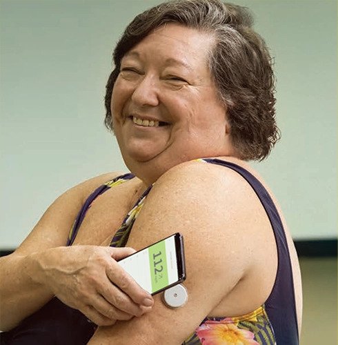 Mulher medindo o nível de glicose apontando o celular para o Sensor FreeStyle Libre