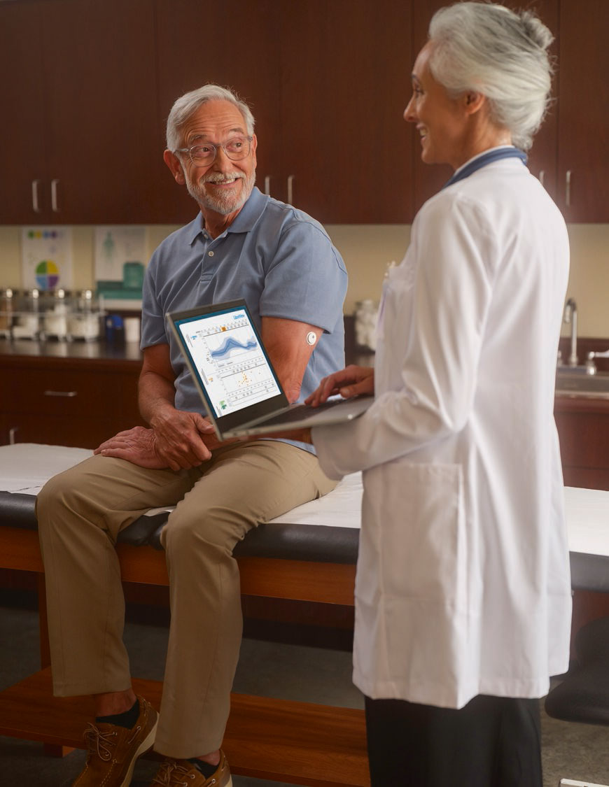 Patient und Ärztin mit Diabetes-Management System FreeStyle Libre View auf Monitor