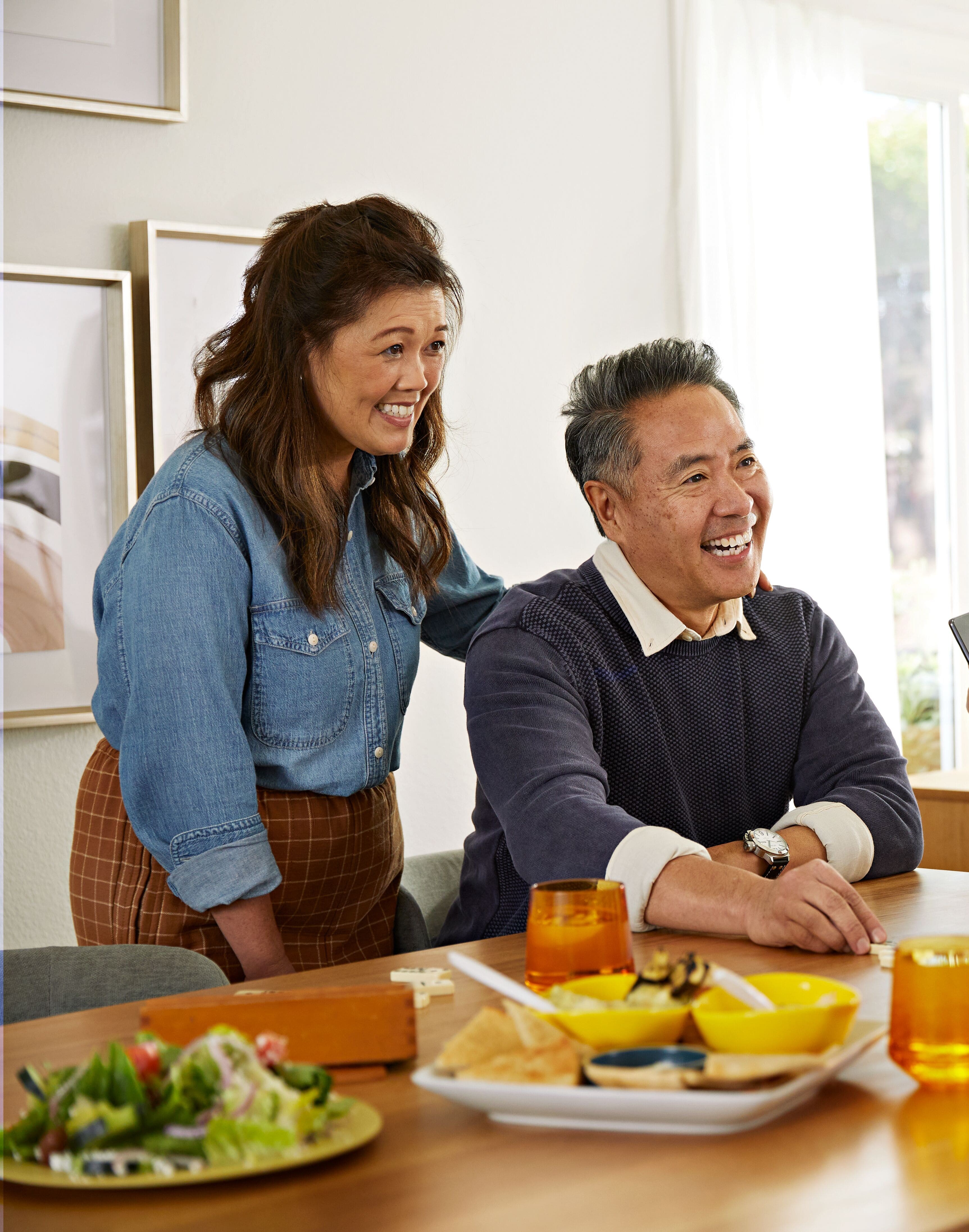 Un homme et une femme à table, en train de rire.