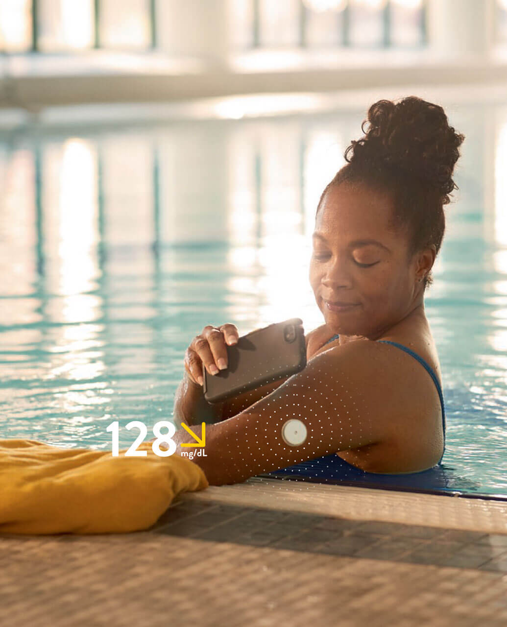 mujer escaneando sus niveles de glucosa con el sensor freestyle y librelink en la piscina.