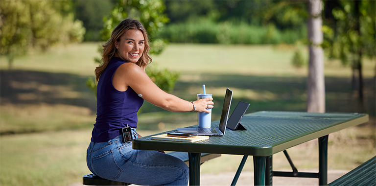 Smiling man wearing a FreeStyle Libre 2 Plus sensor and Omnipod® 5 insulin pump checks his blood glucose
