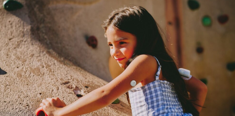 Child wearing a FreeStyle Libre 3 Plus sensor and Omnipod® 5 insulin pump