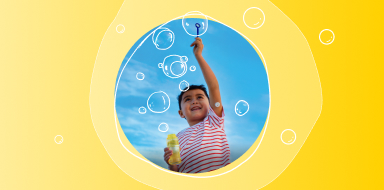 Child playing with bubbles while wearing a FreeStyle Libre 3 Plus sensor