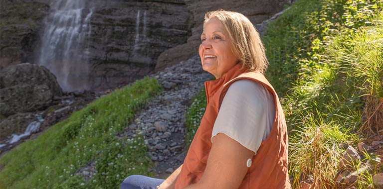 Woman standing outdoors while wearing a FreeStyle Libre 3 Plus sensor