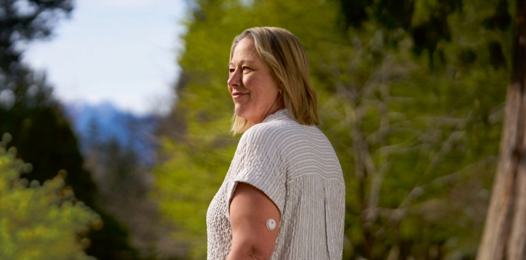 Woman outdoors wearing a FreeStyle Libre 3 Plus sensor