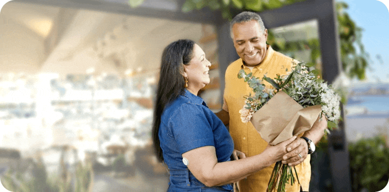 A man giving flowers to a woman while she wears a CGM sensor