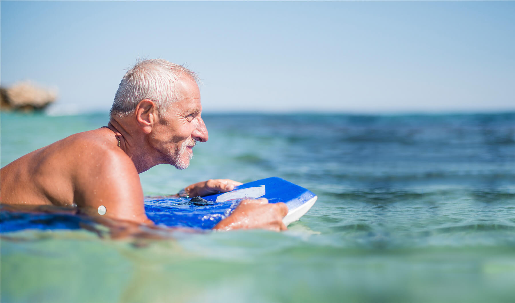 Mann auf Schwimmbrett im Meer