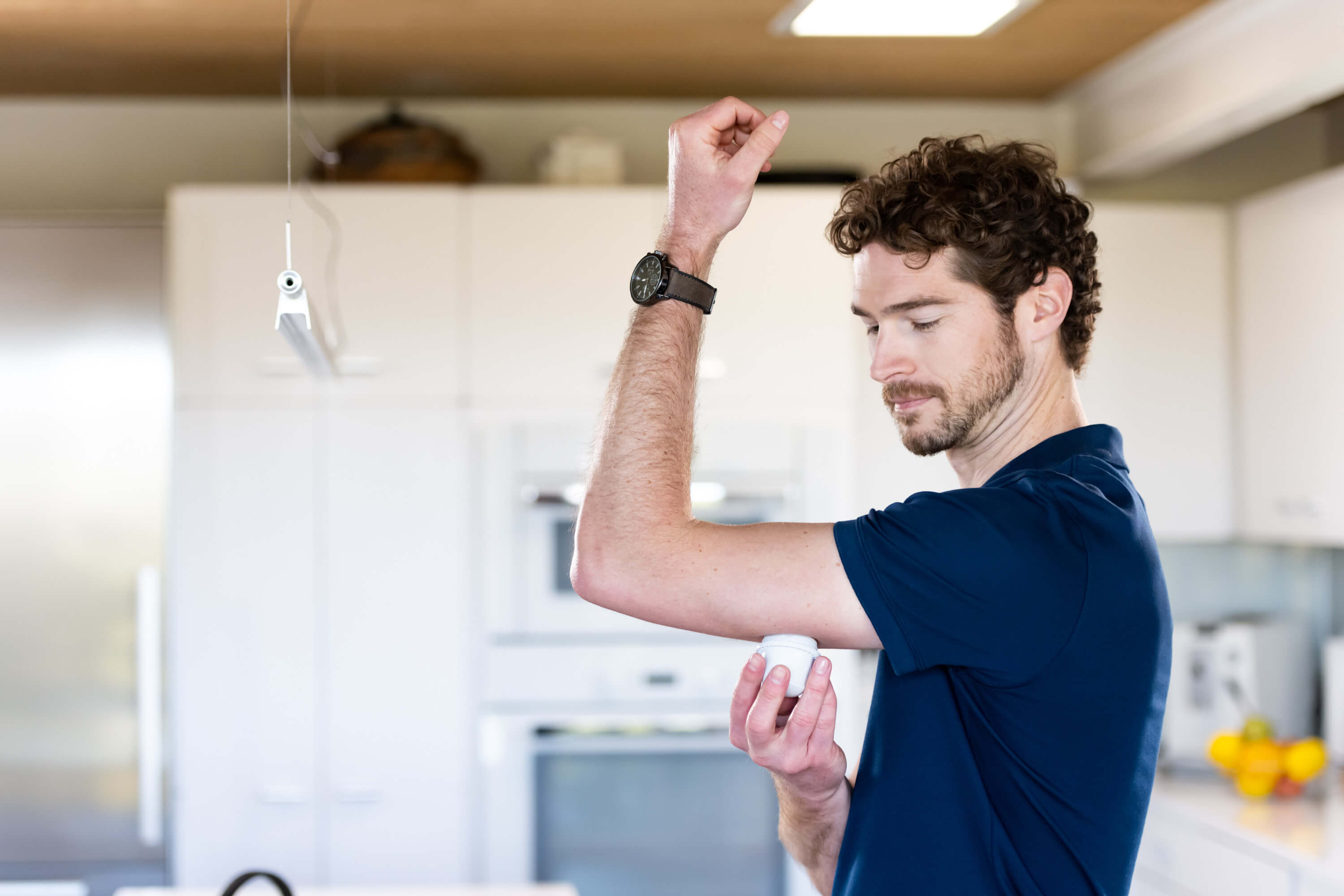 Mann bringt mit Sensorapplikator den FreeStyle Libre 3 Sensor an.