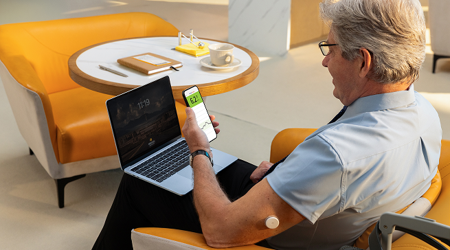 Man wearing Libre sensor looking at his mobile device