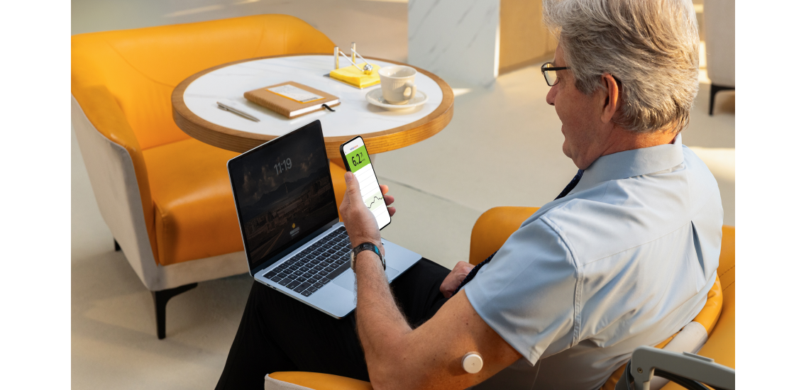 Man wearing Libre sensor looking at his mobile device