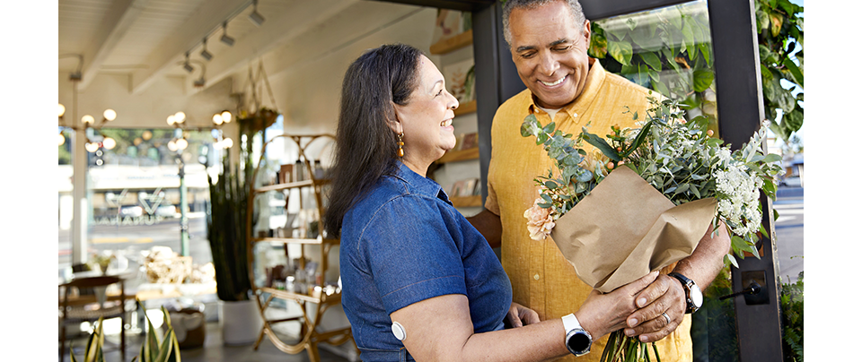 A smiling couple holding a bouquet of flowers