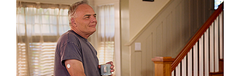 Man wearing FreeStyle Libre 3 Plus sensor in kitchen