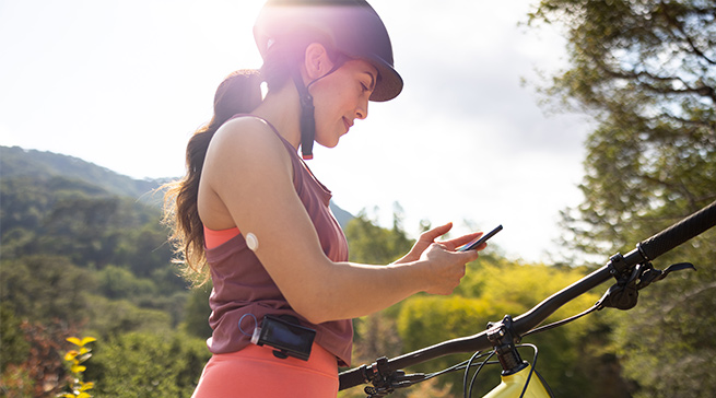 Woman using the Ypsomed insulin pump with the FreeStyle Libre 3 system