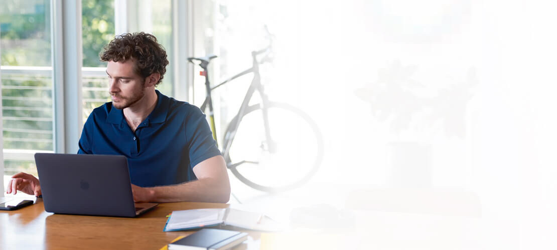 Man sitting at desk and using his laptop
