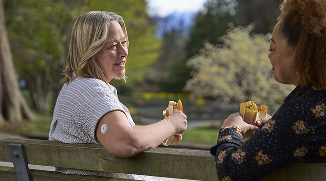 FreeStyle LibreLink home screen shown on a smarphone next to FreeStyle Libre 2 Plus sensor