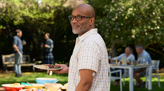 Man at BBQ wearing FreeStyle Libre 2 sensor