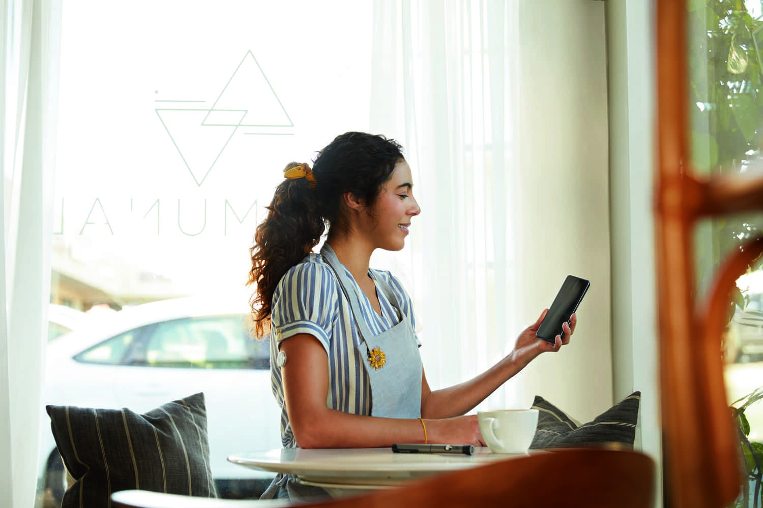 Une femme regarde son téléphone avec un capteur sur le haut du bras.