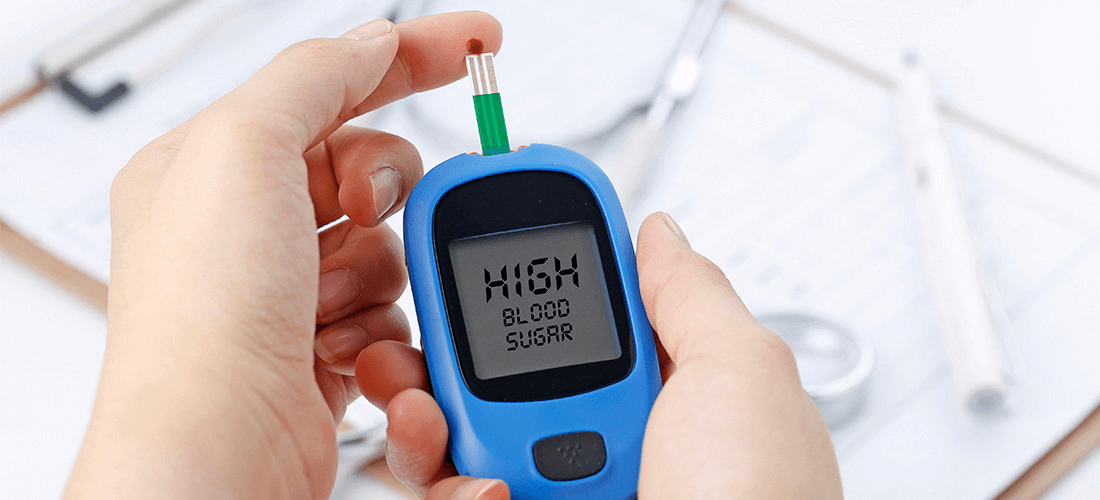 A person adds blood from a pinprick on their finger to their Blood Glucose Monitor.