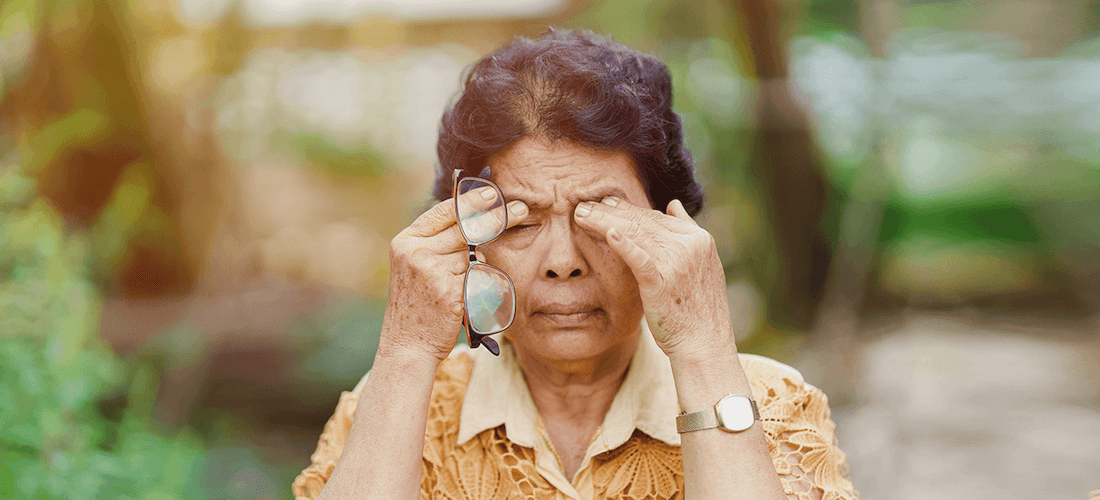 A middle-aged woman removes her glasses and rubs her eyes.