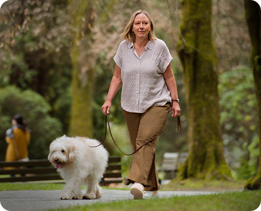 Kvinna går med hunden i en park