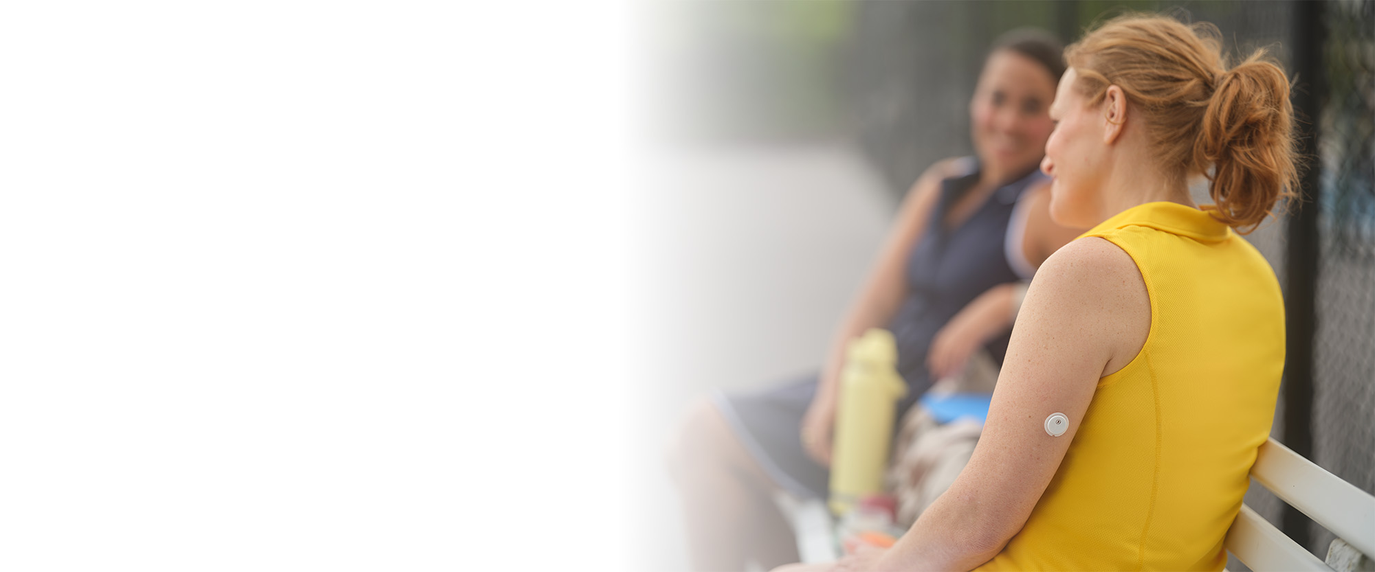Women with coffee smiling while the FreeStyle Libre sensor is visibile on the back of her arm.