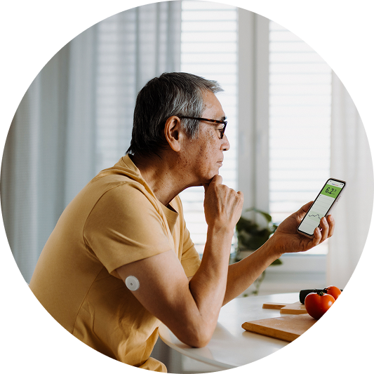 a man looking at glucose data on his phone with a visible sensor on his arm