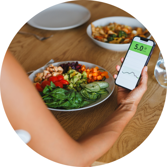 Person viewing their LibreLink app data on their phone while eating