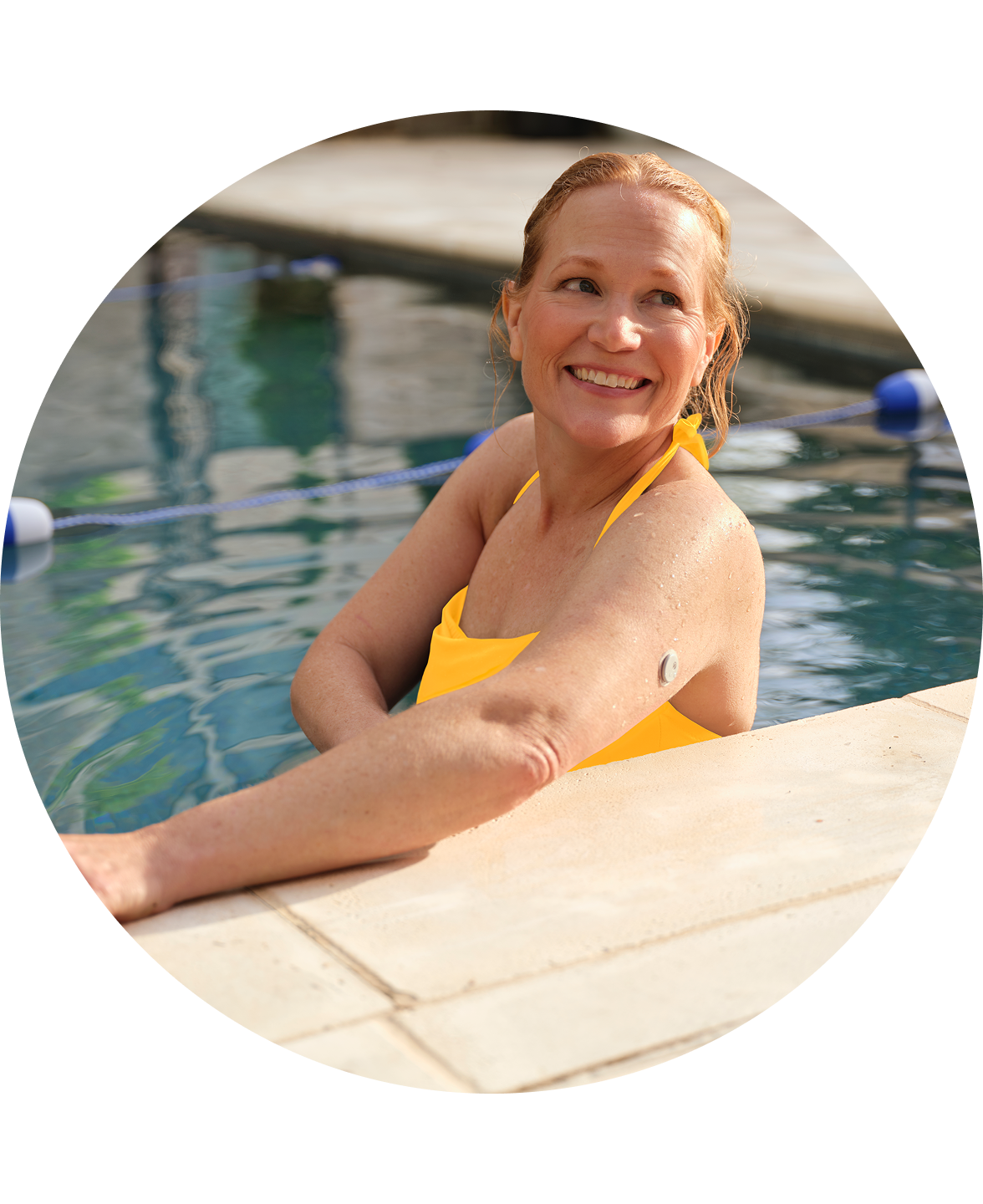 Woman wearing Libre 3 sensor in the pool looking back and smiling