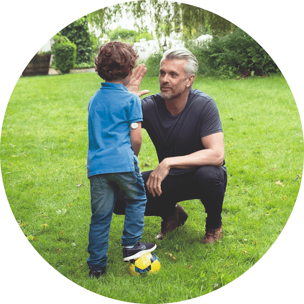 Child wearing Libre sensor playing soccer with his father