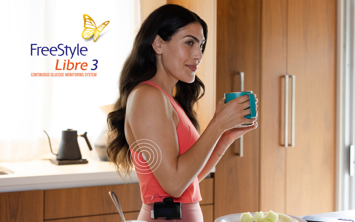 Ypsomed user enjoying breakfast while the FreeStyle Libre 3 system connects to her Ypsomed device