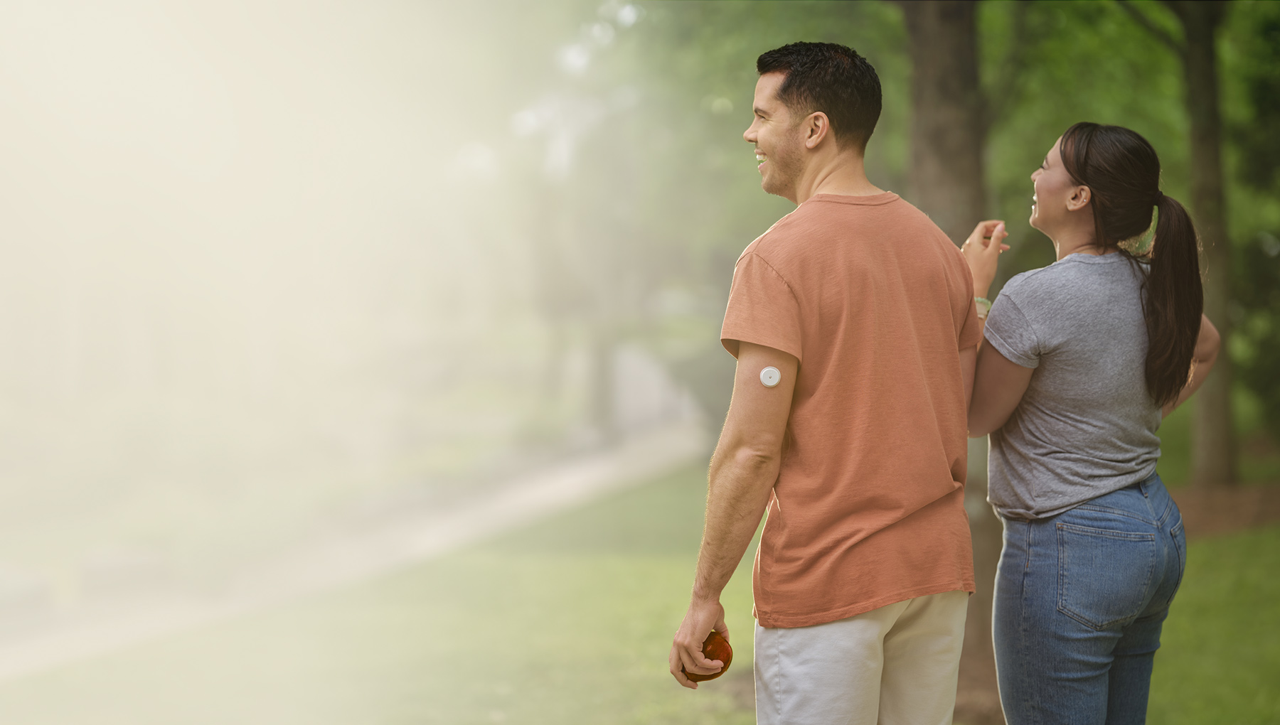 Man wearing Libre 2 Plus sensor walking in a garden with a friend