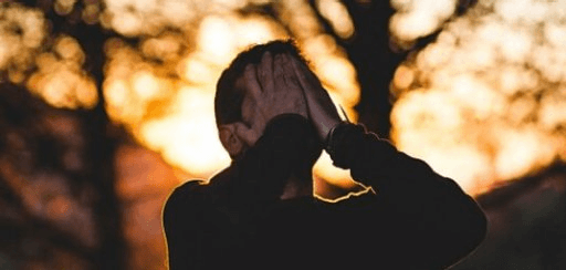 A man covers his face with his hands to reduce his stress levels