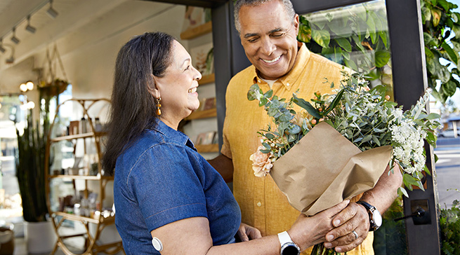A woman with a Libre 2 sensor with a man holding a bouqet of flowers