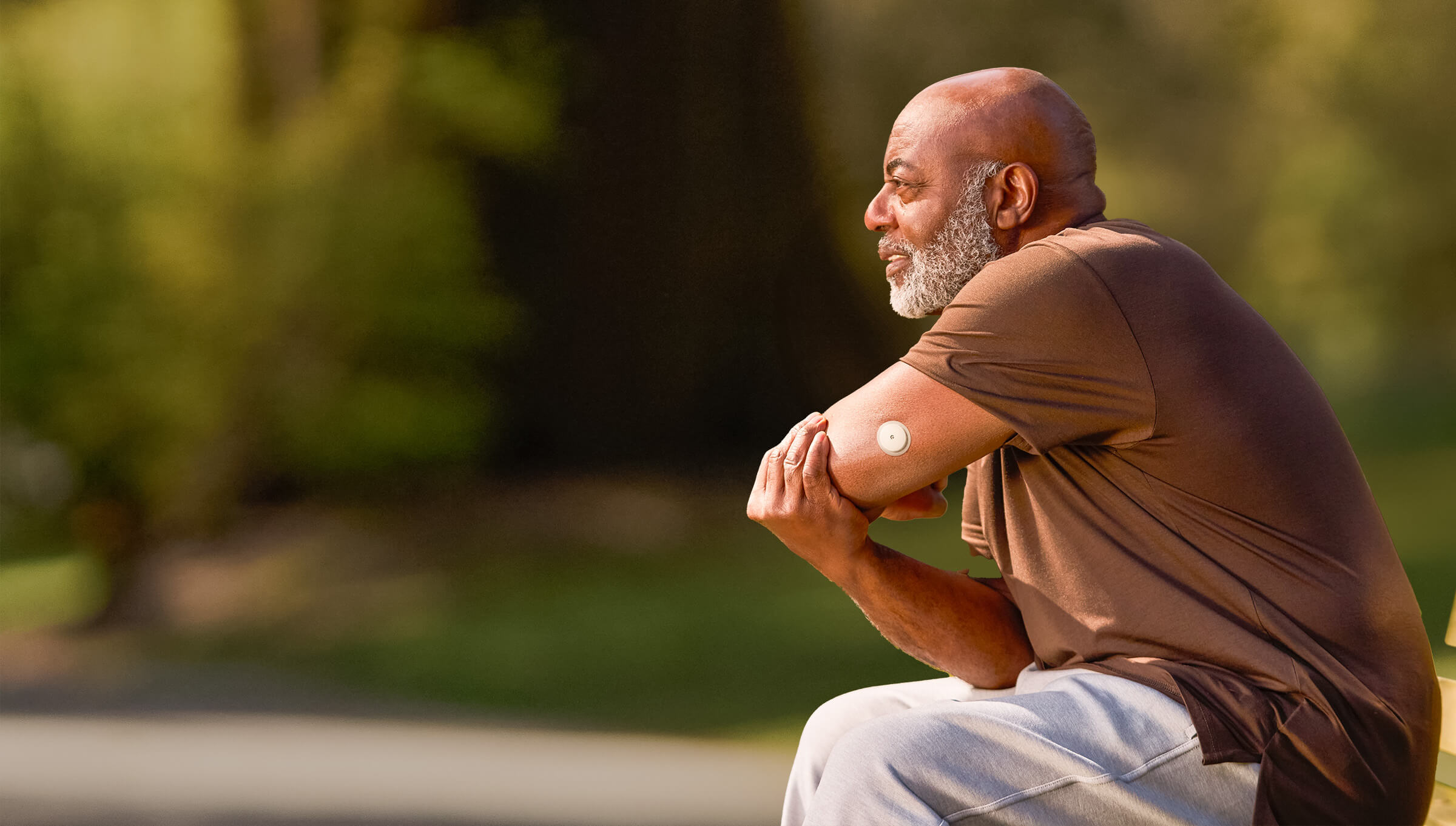 Man with sensor stretching in the park