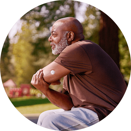 A man wearing a FreeStyle Libre sensor stretching outside.