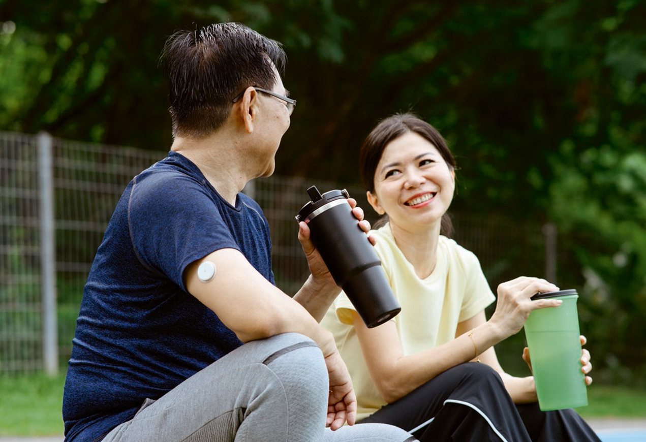 Woman exercising outside stops to take a sip from her water bottle.