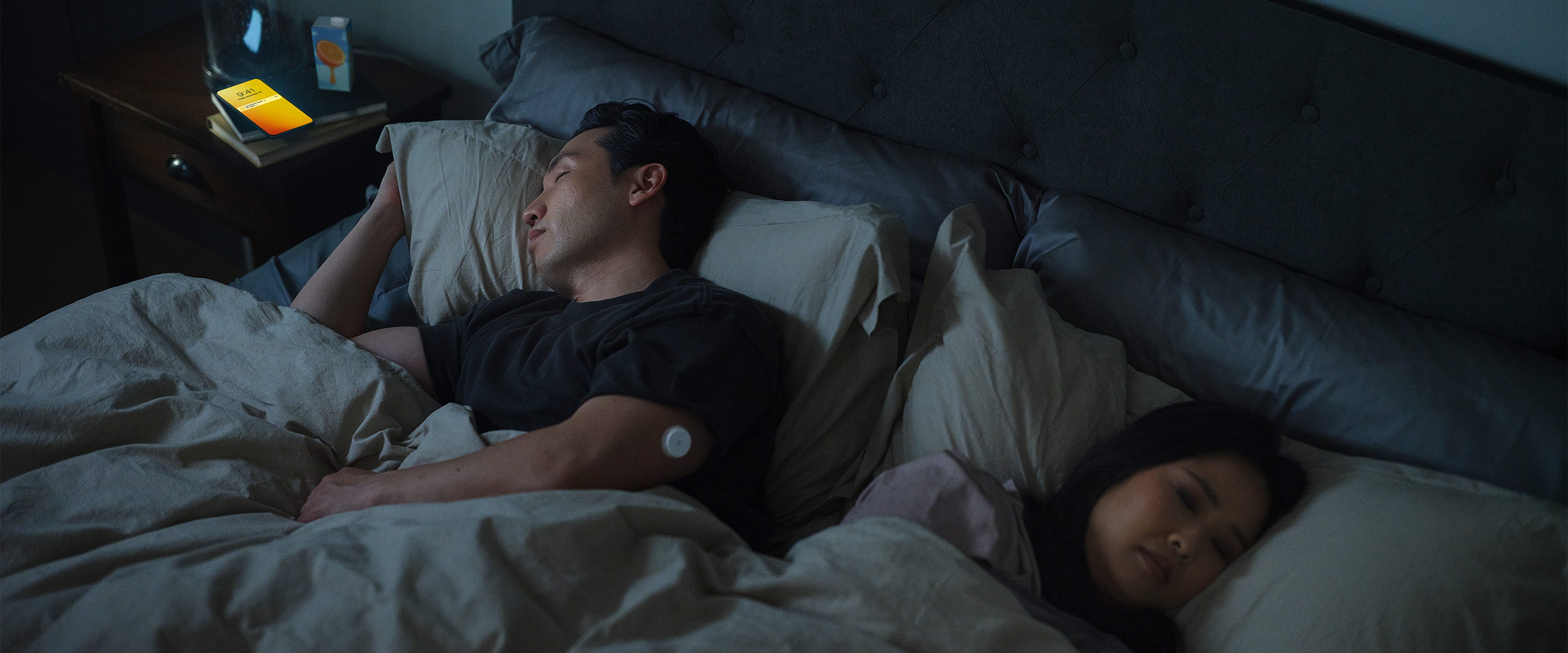 Person wearing FreeStyle Libre sensor checking glucose levels on their phone after waking up.