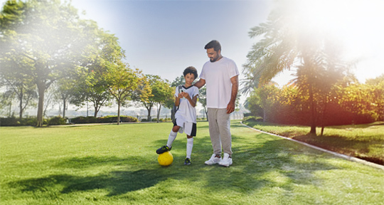 An image of dad and teen looking at the smartphone screen.