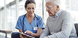 Doctora explicándole a hombre mayor hipoglucemia e hiperglucemia