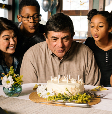 Man blowing out candles of birthday cake