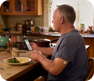 Man wearing a FreeStyle Libre continuous glucose monitoring (CGM) sensor checking his blood glucose