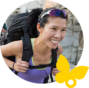 Smiling woman wearing a backpack on a hike