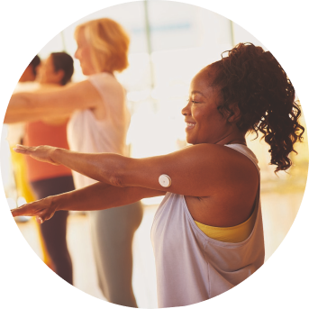 Woman taking part in a group exercise class while wearing a FreeStyle Libre sensor