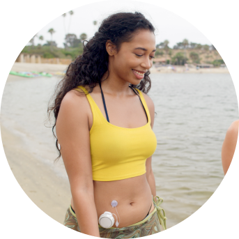 Woman walking on a beach while wearing the twiist™ AID System