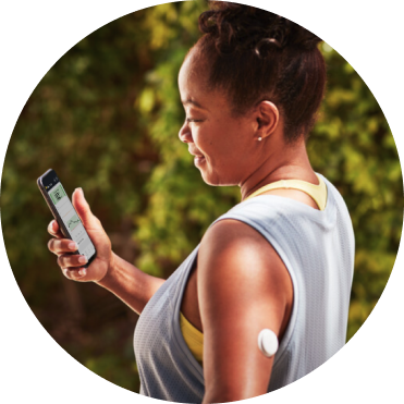 Woman walking in the woods wearing a FreeStyle Libre 2 Plus sensor